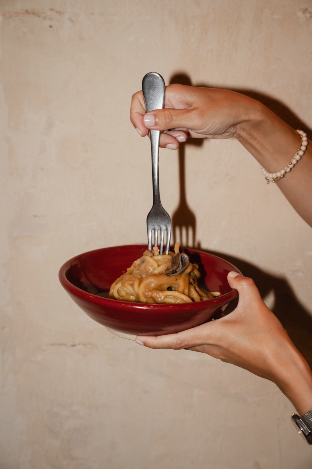 Plato de pasta servido en un cuenco rojo